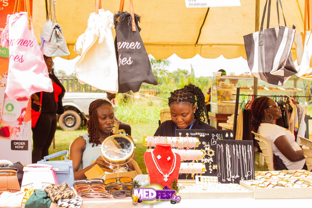 A jewellery and bag stall under a yellow tent